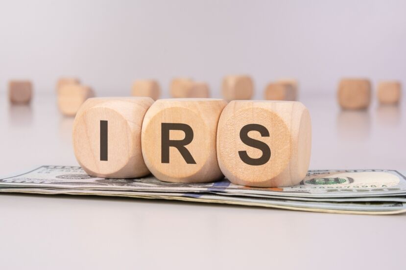 IRS wooden blocks on cash stack, representing US taxes.